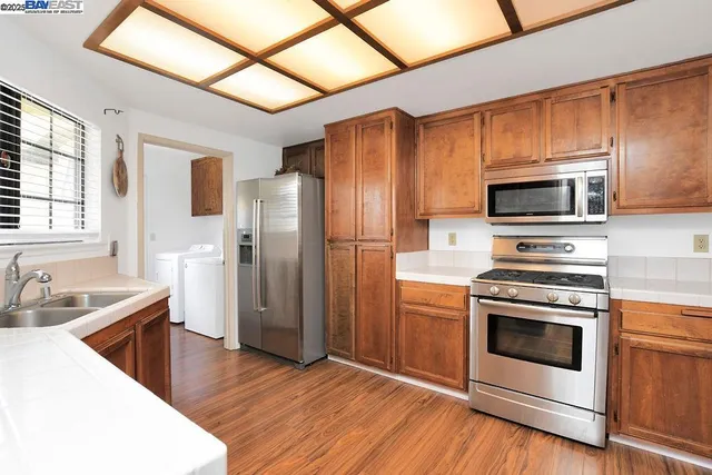 a kitchen with stainless steel appliances granite countertop a sink stove and refrigerator
