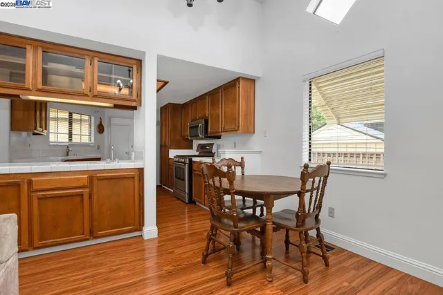 a kitchen with stainless steel appliances granite countertop wooden cabinets sink and stove top oven