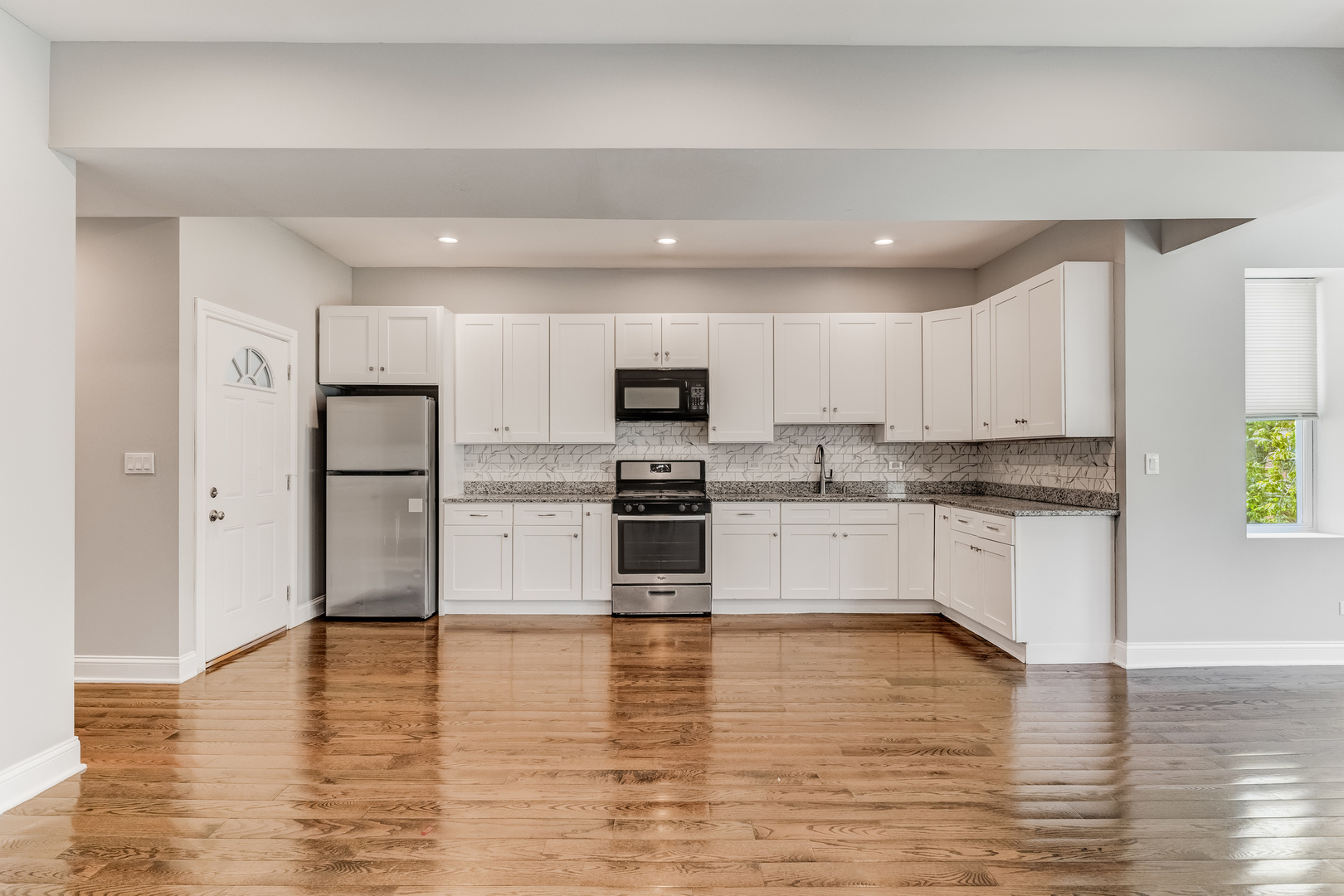 1321 South Millard Avenue, Unit C Chicago, IL 60623 - Photo 3 of 13 a kitchen with stainless steel appliances granite countertop a refrigerator sink and white cabinets