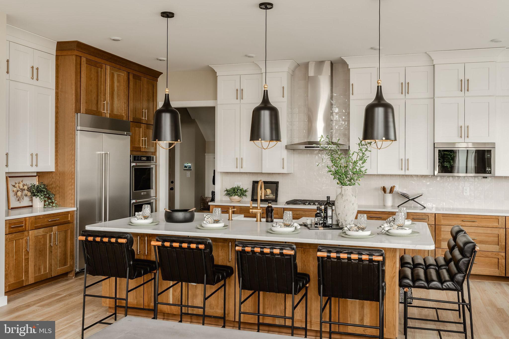 1100 Dietz Road, Unit DEVONSHIRE York, PA 17402 - Photo 14 of 50 a kitchen with stainless steel appliances granite countertop a refrigerator a sink dishwasher a dining table and chairs with wooden floor