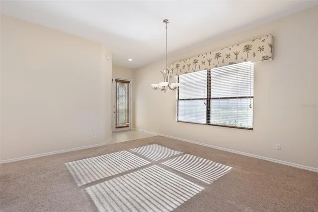 an empty room with windows and ceiling fan