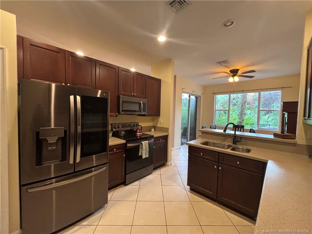 262 Southwest Walking Path, Unit 262 Stuart, FL 34997 - Photo 3 of 39 a kitchen with granite countertop a refrigerator and a sink