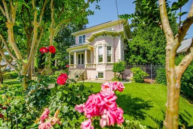 a front view of house and yard with beautiful flowers