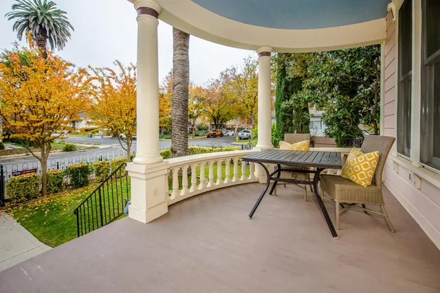 a bedroom with a bed and chair with the large mirror