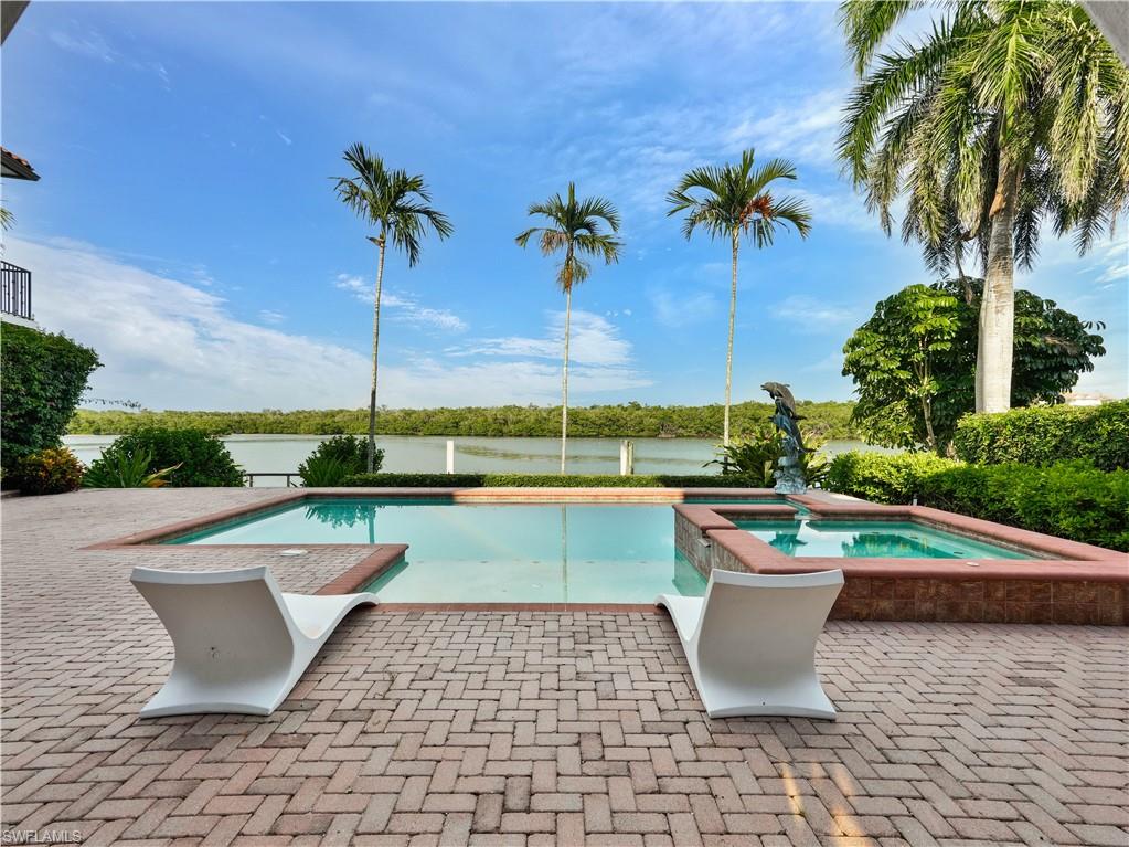 2535 Tarpon Road Naples, FL 34102 - Photo 41 of 50 Waterfront dock with a boat lift, composite decking, and concrete seawall