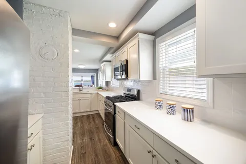 a kitchen with white cabinets and white appliances