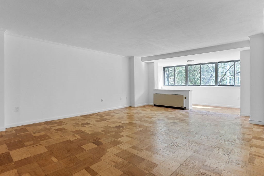 a view of empty room with a fireplace and white walls
