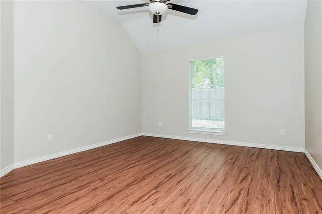 wooden floor in an empty room with a window