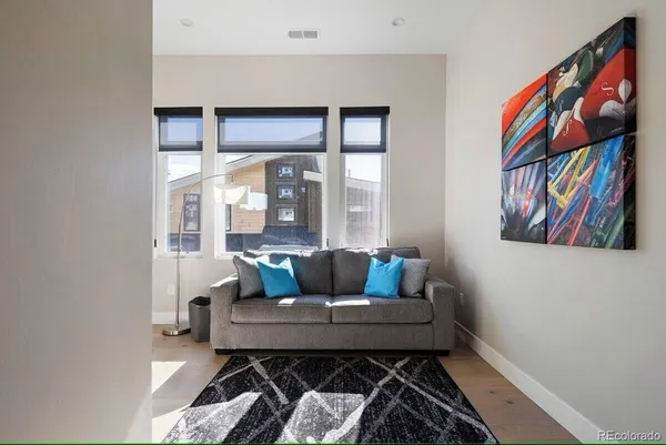 a living room with furniture and a painting on the wall