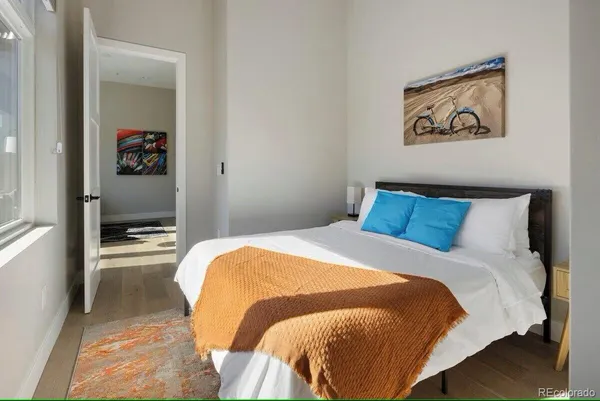 a bedroom with a bed and painting on the wall