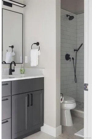 a bathroom with a sink a toilet and shower