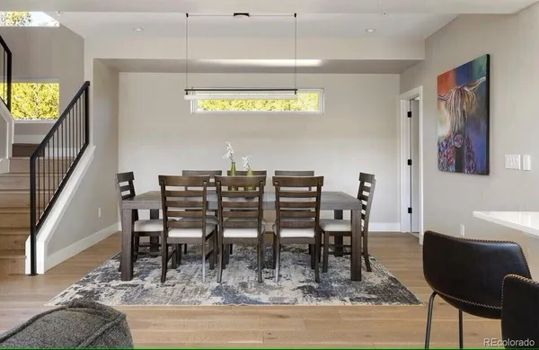 a dining room with furniture and a floor to ceiling window