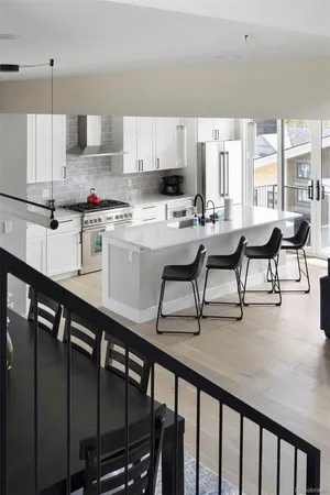 a kitchen with stainless steel appliances granite countertop table chairs sink and cabinets