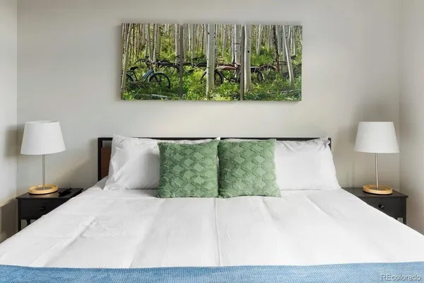 a bed sitting in a bedroom next to a lamp