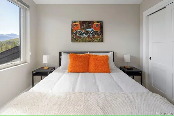 a bedroom with a large bed and a painting on the wall