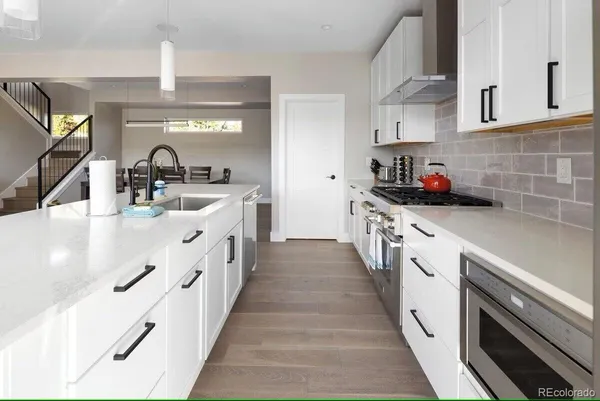 a kitchen with stainless steel appliances a sink stove top oven and cabinets