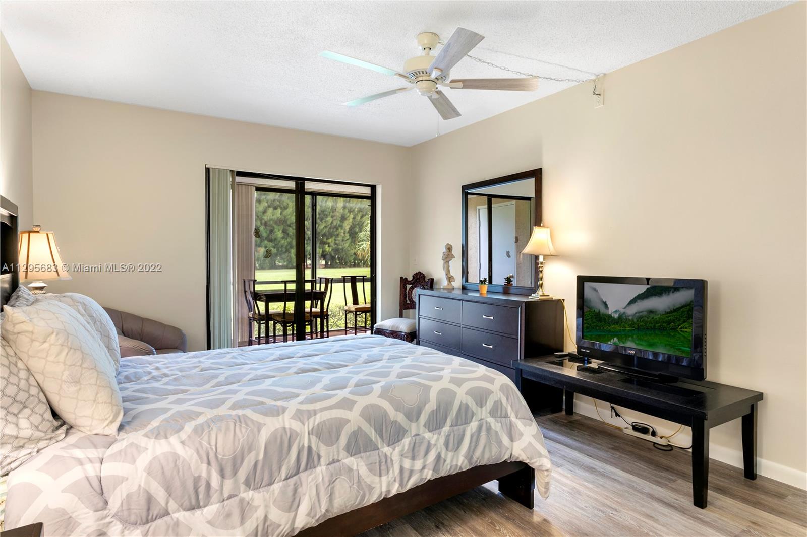 101 Pinecrest Circle, Unit E Jupiter, FL 33458 - Photo 11 of 20 a bedroom with a bed and a flat screen tv