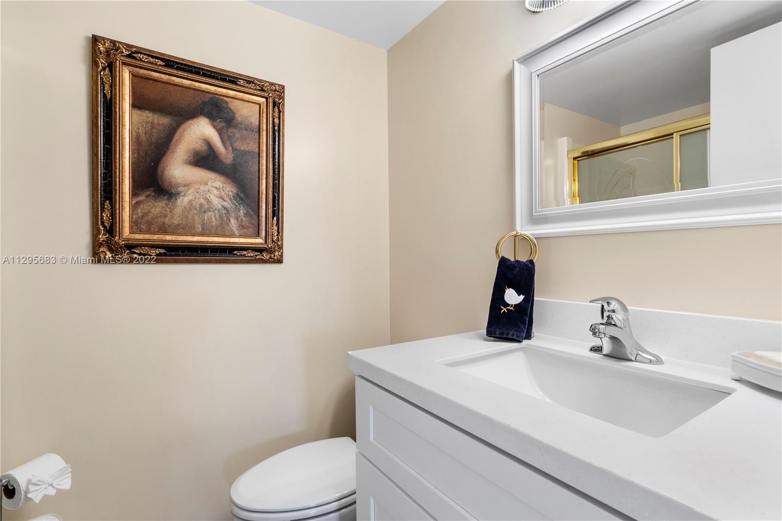 101 Pinecrest Circle, Unit E Jupiter, FL 33458 - Photo 15 of 20 a bathroom with a toilet sink and mirror