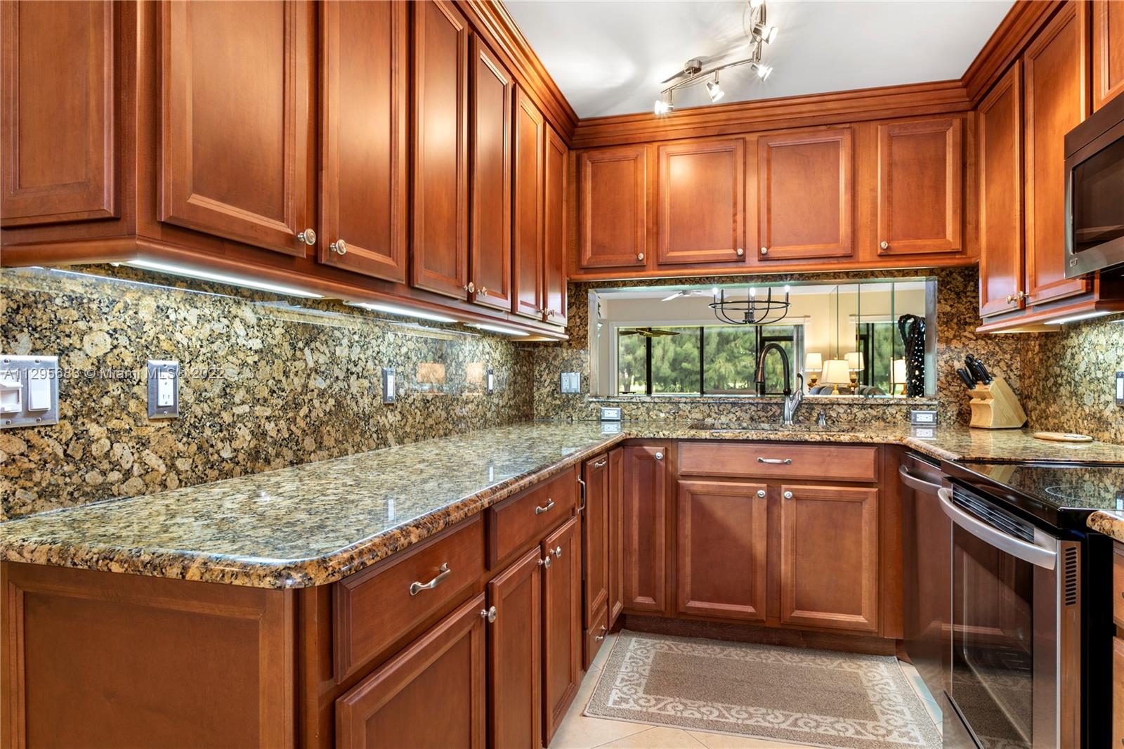 101 Pinecrest Circle, Unit E Jupiter, FL 33458 - Photo 2 of 20 a kitchen with stainless steel appliances granite countertop wooden cabinets a sink and dishwasher