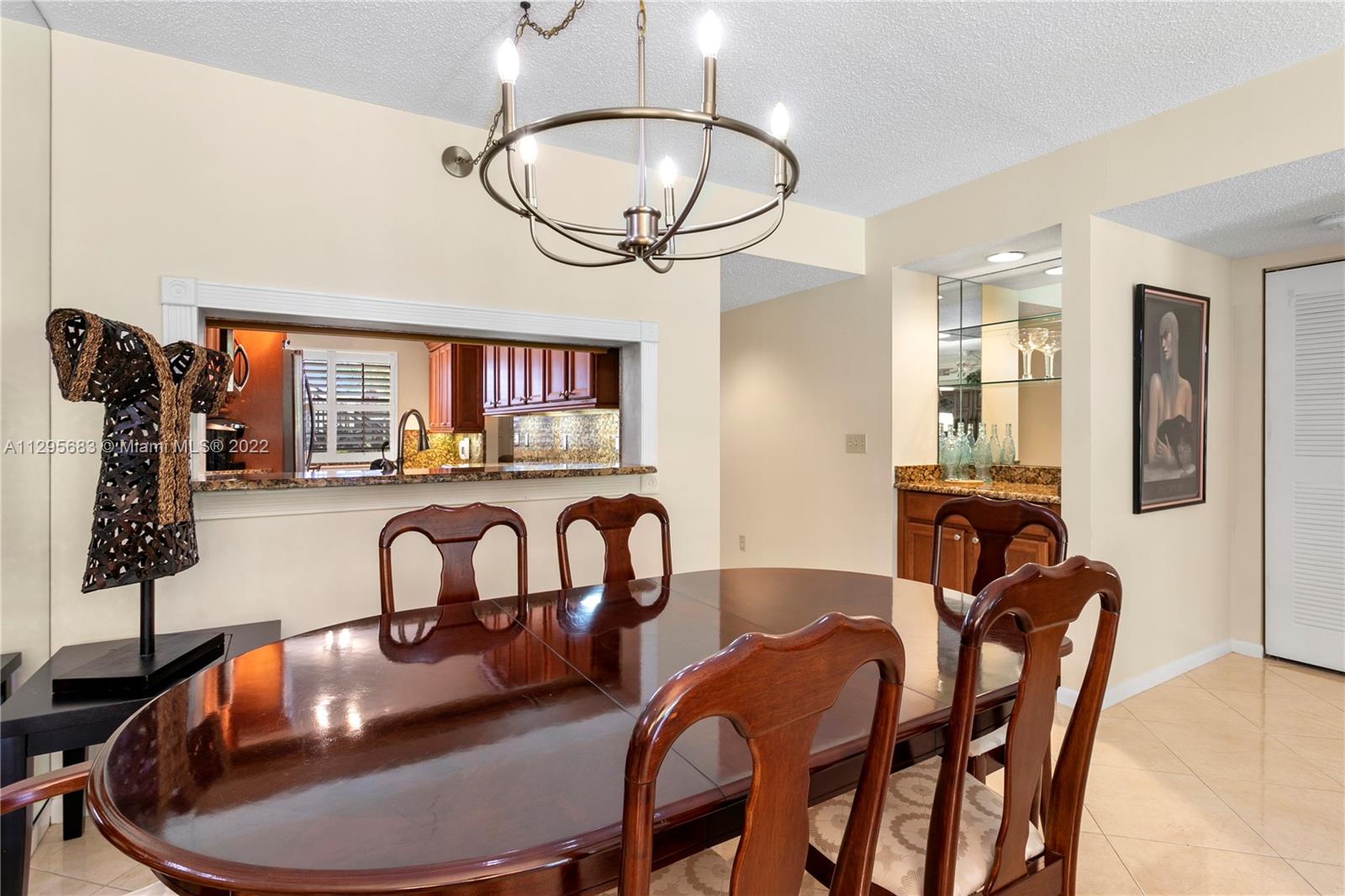 101 Pinecrest Circle, Unit E Jupiter, FL 33458 - Photo 5 of 20 a dining room with furniture a front door and wooden floor