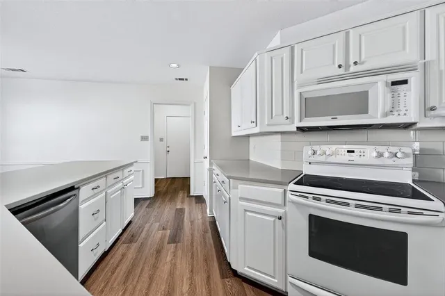 an empty room with a ceiling fan and wooden floor