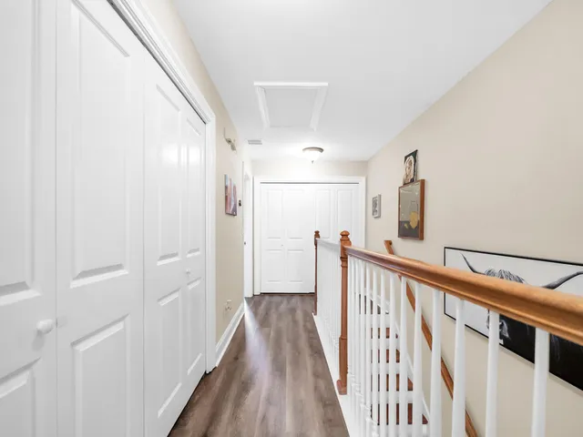 a view of a hallway with wooden floor and staircase