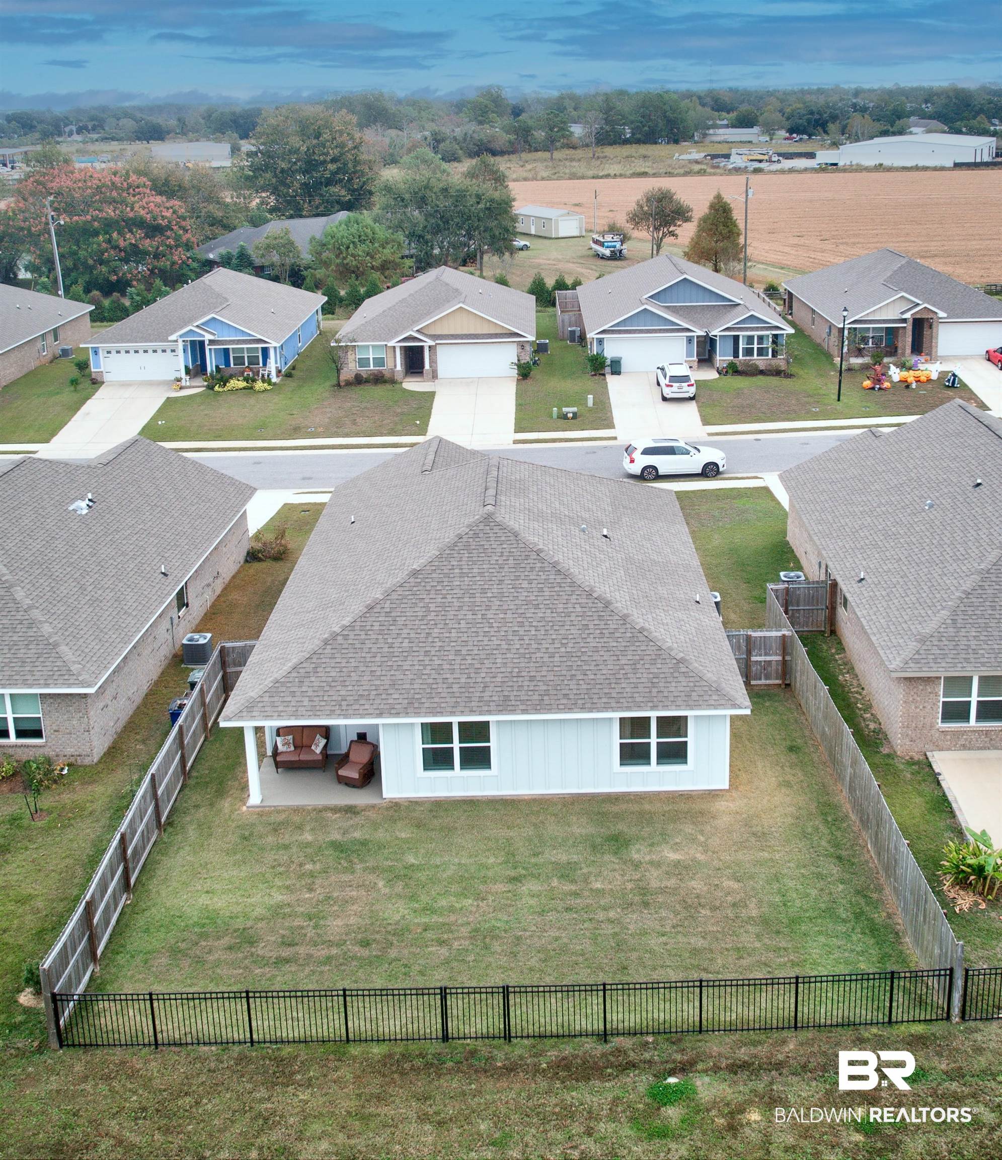8033 Irwin Loop Daphne, AL 36526 - Photo 5 of 38 Rear exterior featuring a covered patio, a fenced backyard, and light blue siding