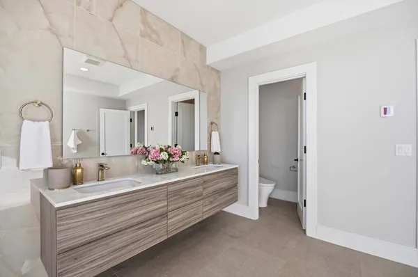 a bathroom with a double vanity sink mirror and toilet