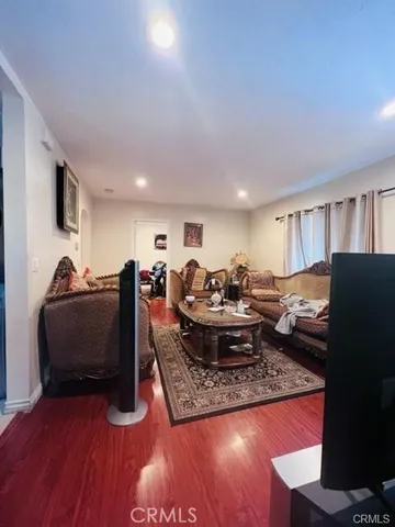 a living room with furniture a flat screen tv and a table