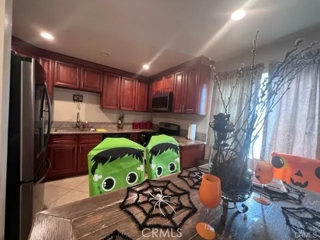 a kitchen with stainless steel appliances granite countertop a refrigerator a stove and a wooden cabinets