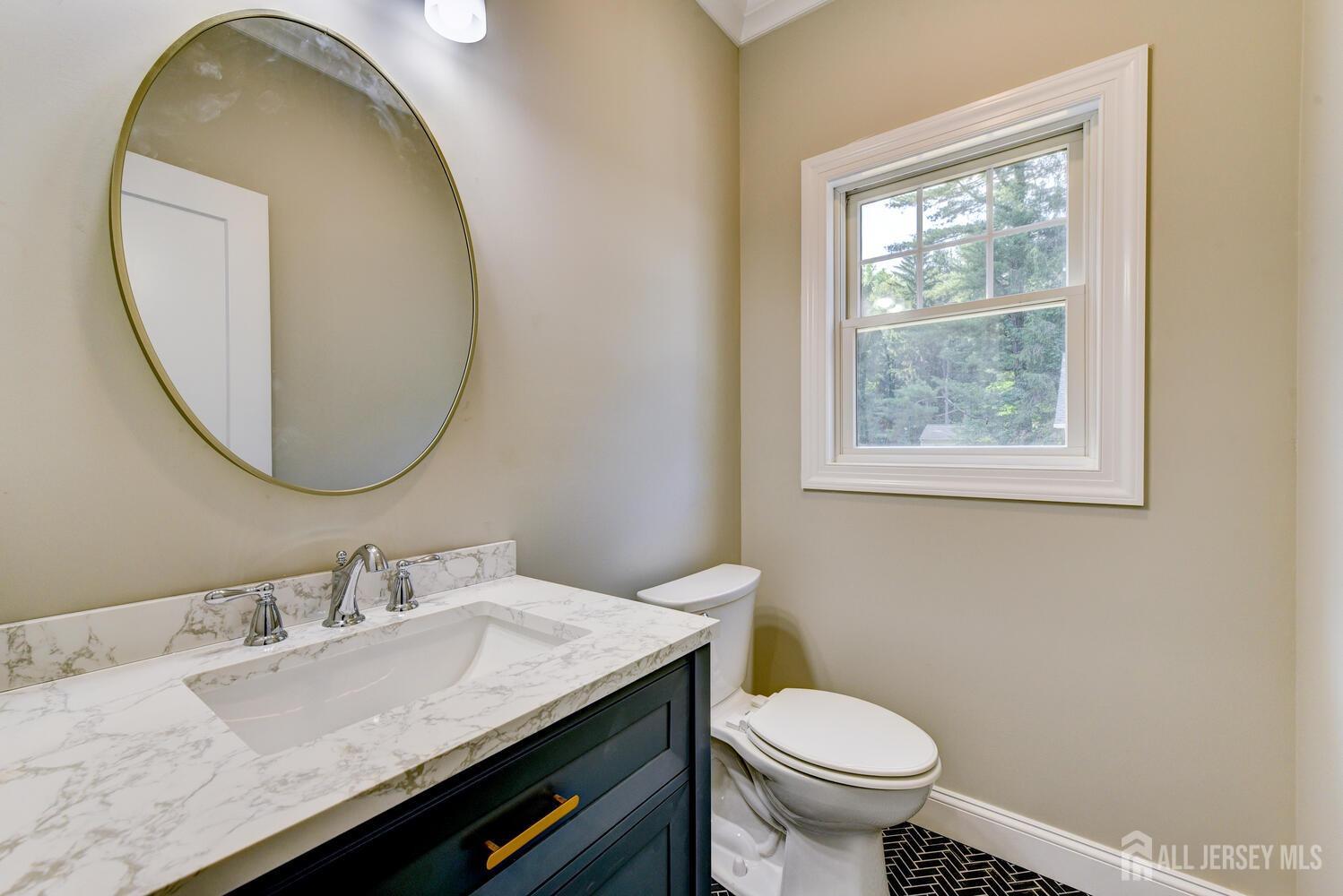 923 Iron Bridge Road Asbury, NJ 08802 - Photo 22 of 41 a bathroom with a granite countertop toilet a sink and a mirror