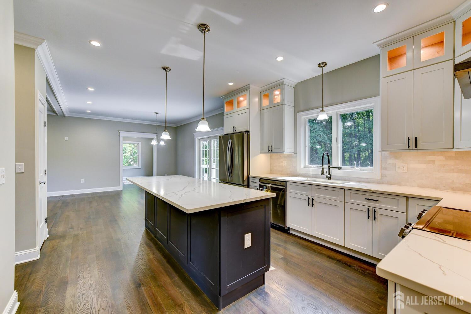 923 Iron Bridge Road Asbury, NJ 08802 - Photo 25 of 41 a kitchen with a stove a sink dishwasher kitchen island with wooden cabinets and floor
