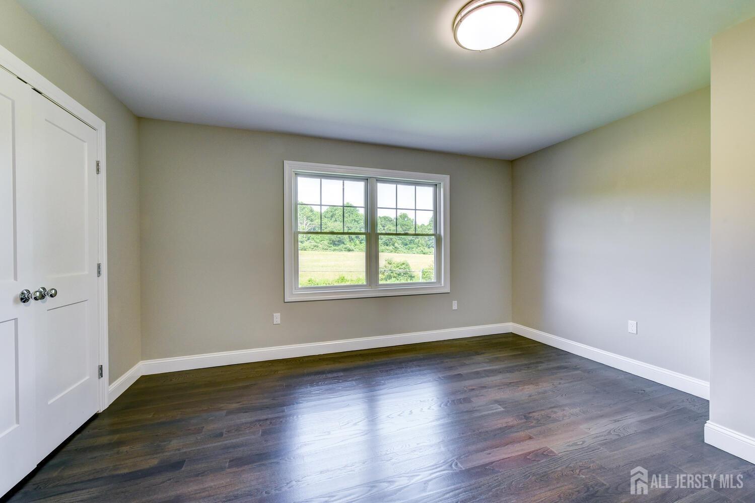 923 Iron Bridge Road Asbury, NJ 08802 - Photo 9 of 41 an empty room with wooden floor and windows