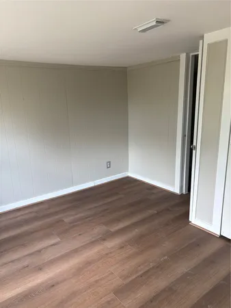 an empty room with wooden floor and window
