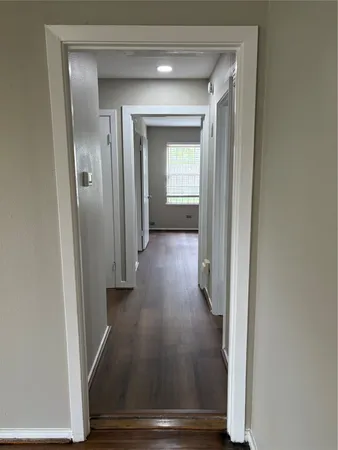 a view of a hallway with wooden floor