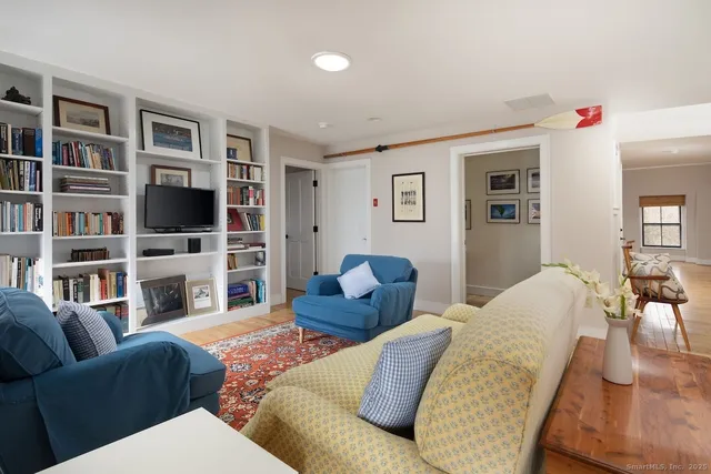 a living room with furniture bookshelf and a flat screen tv