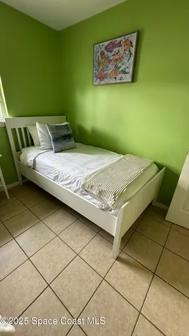 a bedroom with a bed and a wall painting