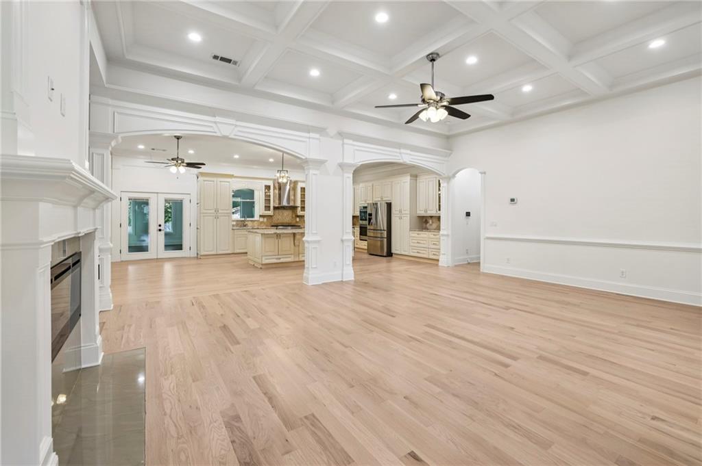 3170 Lavista Road Decatur, GA 30033 - Photo 11 of 29 an empty room with wooden floor ceiling fan and kitchen view