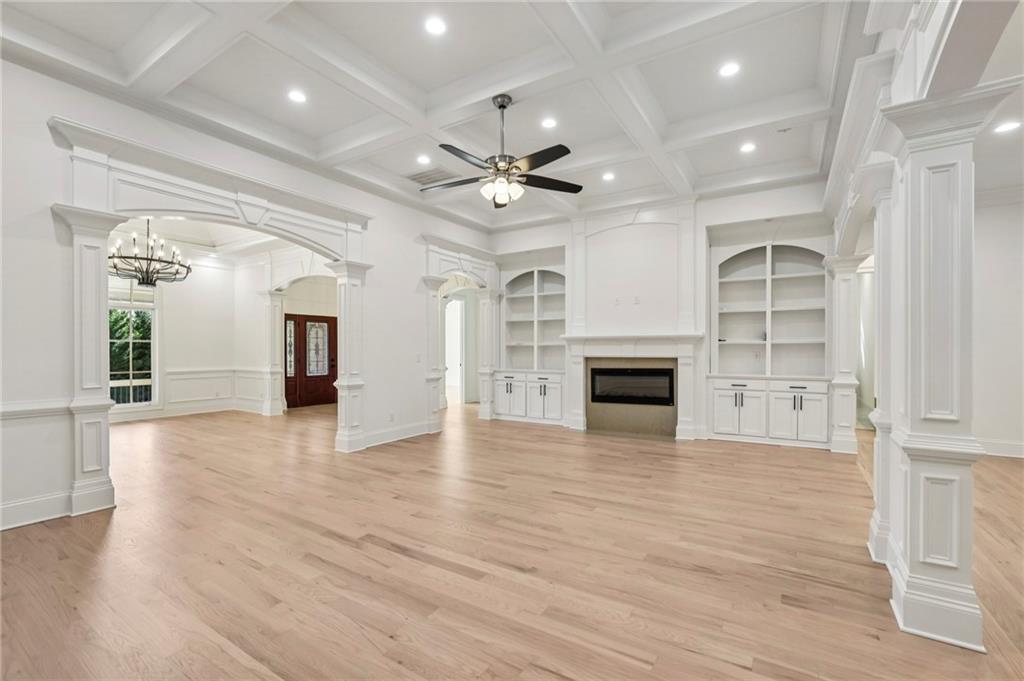 3170 Lavista Road Decatur, GA 30033 - Photo 10 of 29 an empty room with wooden floor a ceiling fan a fireplace and windows