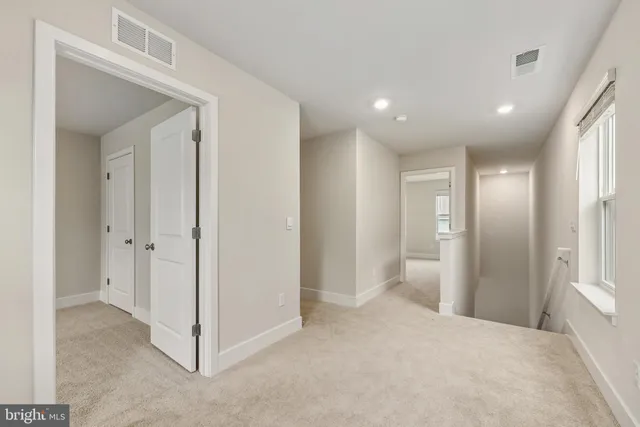 a view of a hallway with closet and bathroom