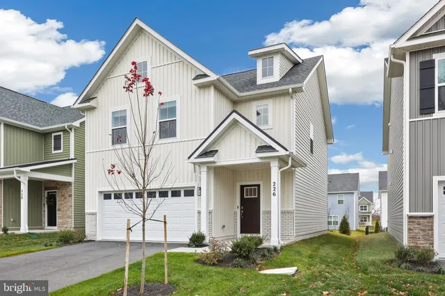 a view of a white house next to a yard