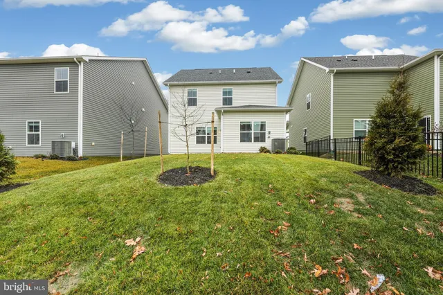 a view of a house with a big yard and large tree