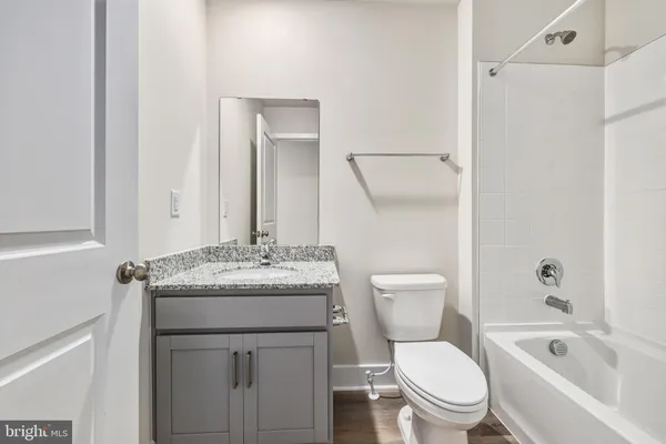 a bathroom with a granite countertop sink mirror and shower