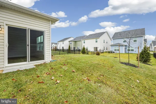 a view of a house with a yard and potted plants
