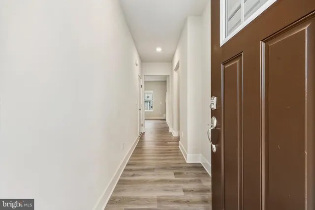 a view of a hallway with wooden floor and staircase