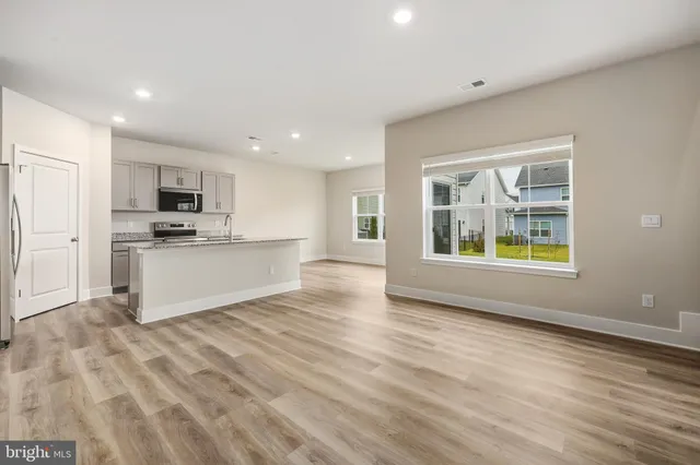 a view of kitchen with stainless steel appliances granite countertop a stove and a sink