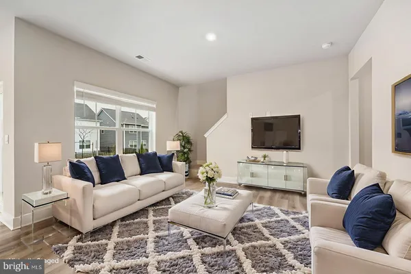 a living room with furniture flat screen tv and a large window