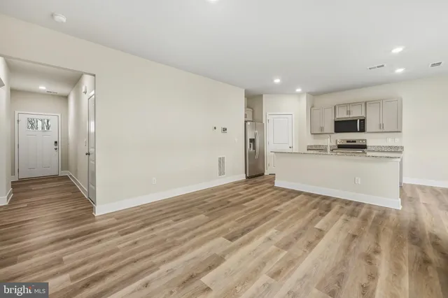 a view of a kitchen with wooden floor and a sink