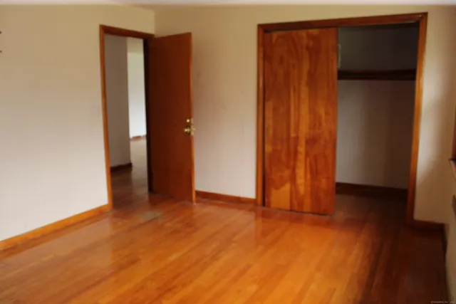 an empty room with wooden floor and closet