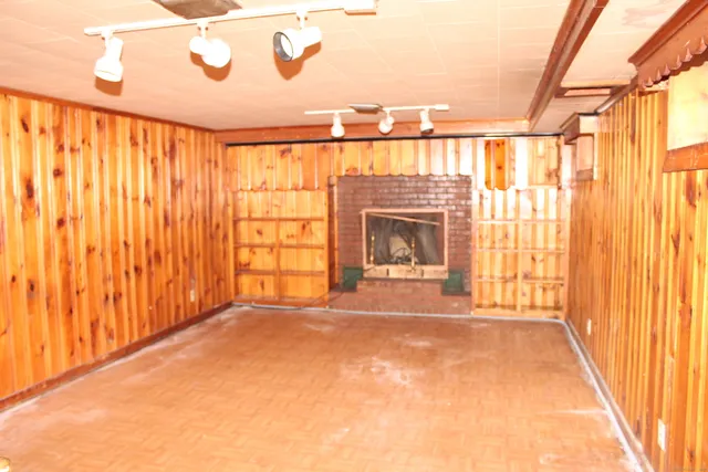 a view of an empty room with a fireplace and a window